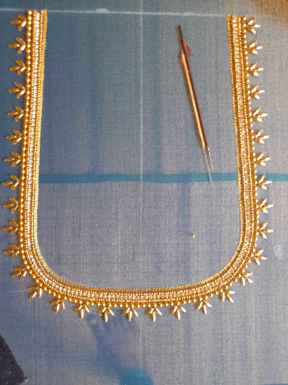 Intricate floral aari neckline design with seed pearls and gold threads
